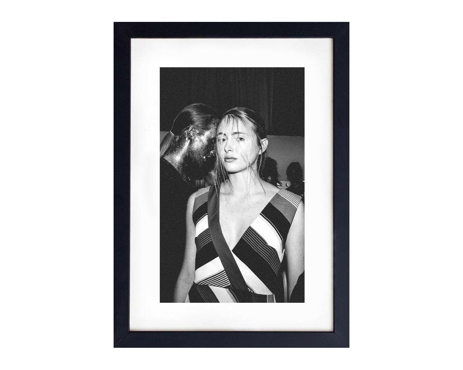 Framed black and white portrait of a woman wearing a patterned dress.