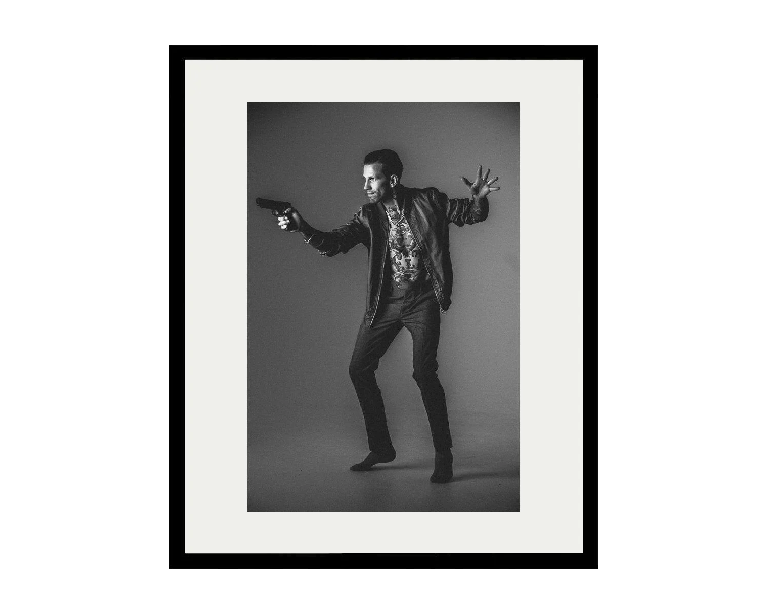 Framed black and white portrait of a man in a dynamic pose.