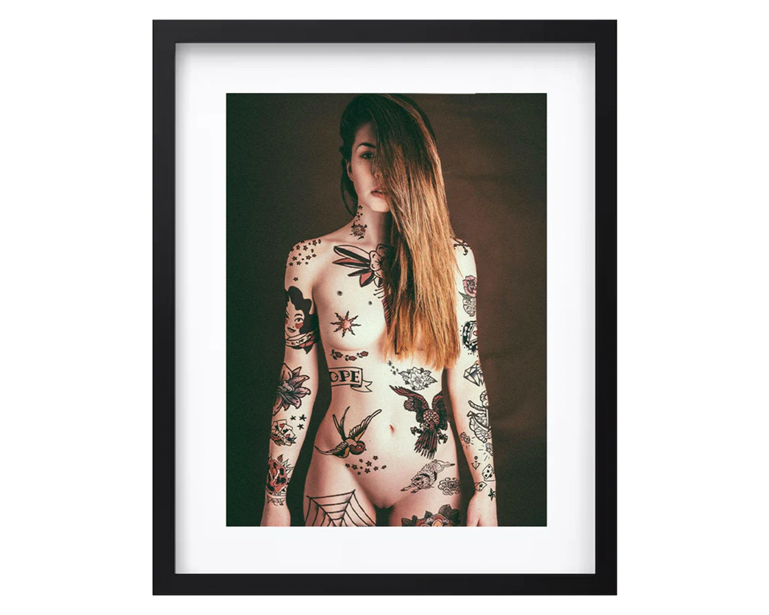 Framed portrait of a woman with tattoos on a white background