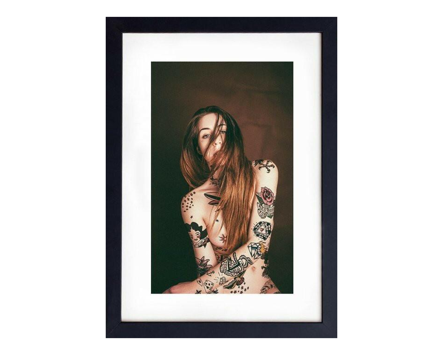 Framed portrait of a woman with tattoos on a white background