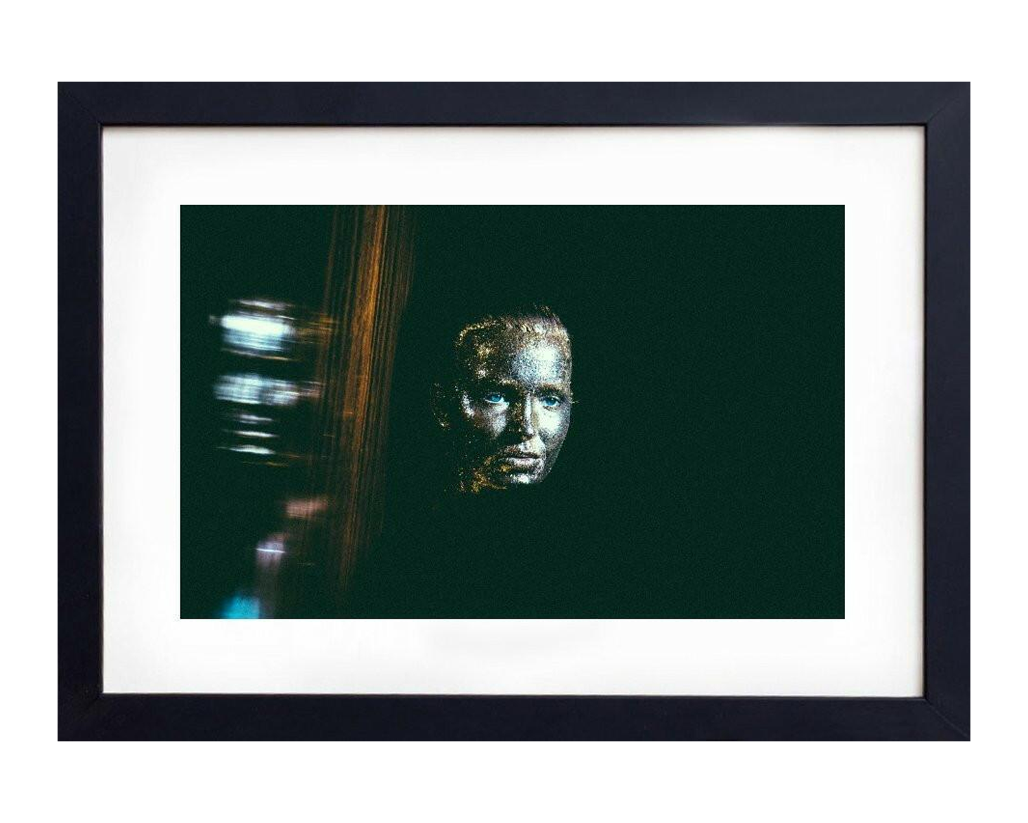 Framed artwork of a stylized face with abstract elements on a dark background