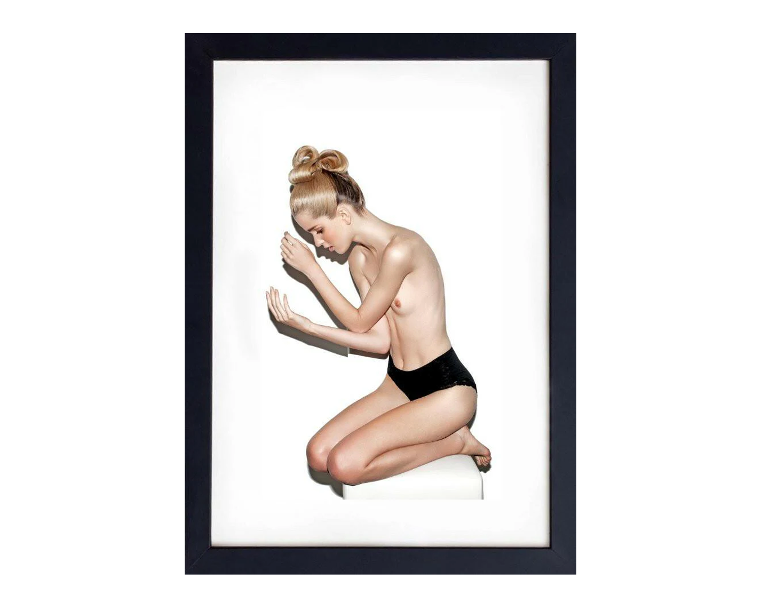Framed artwork of a nude woman in a black frame on a white background