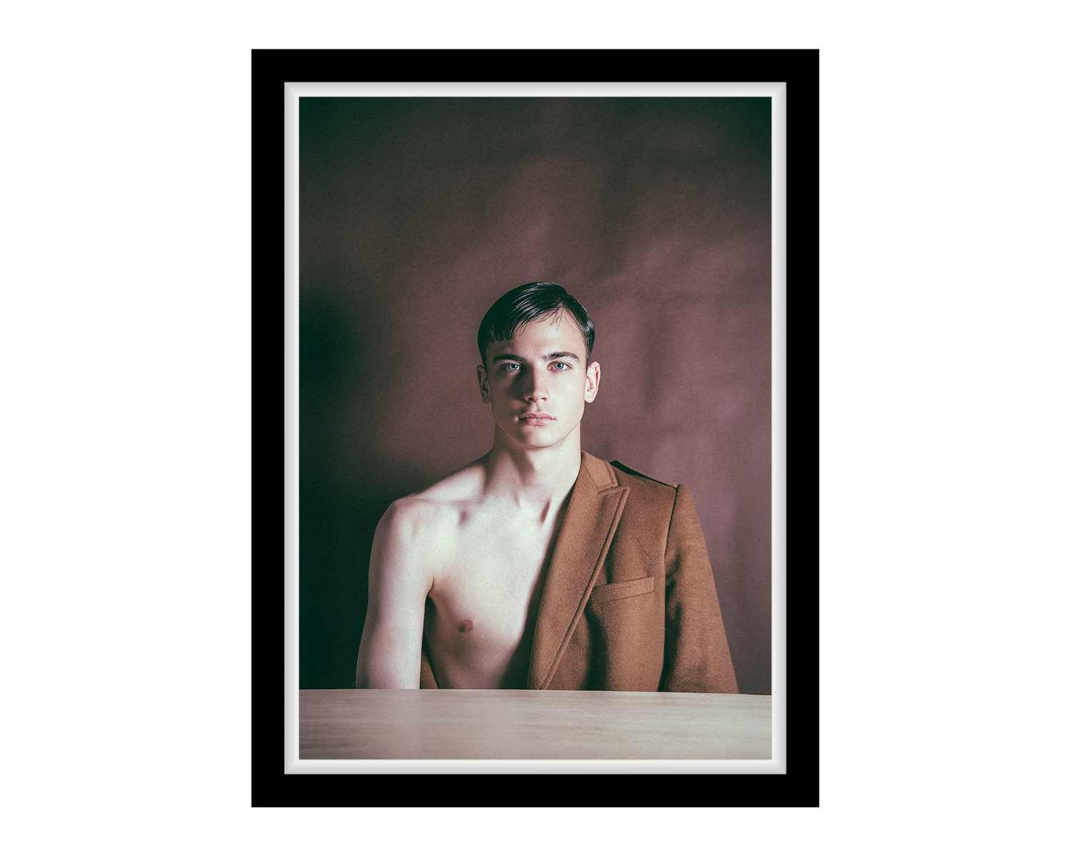 Framed portrait of a person wearing a brown blazer without a shirt underneath.