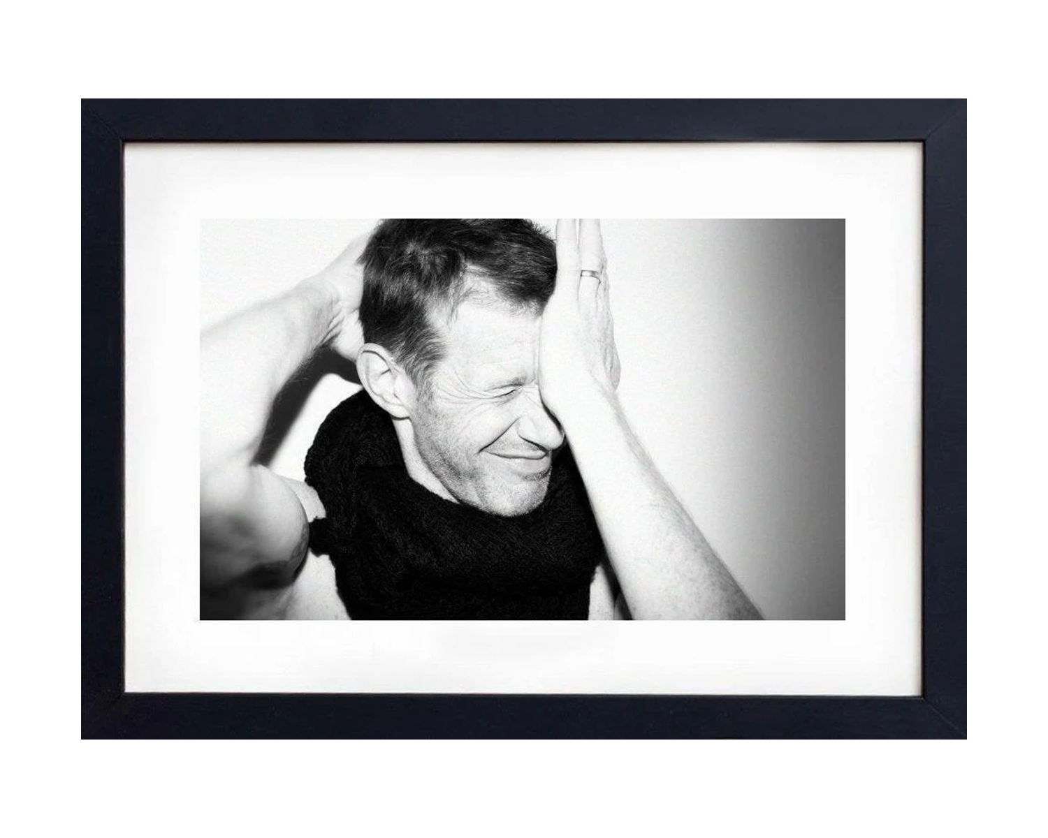 Framed black and white photo of a person with hands on face