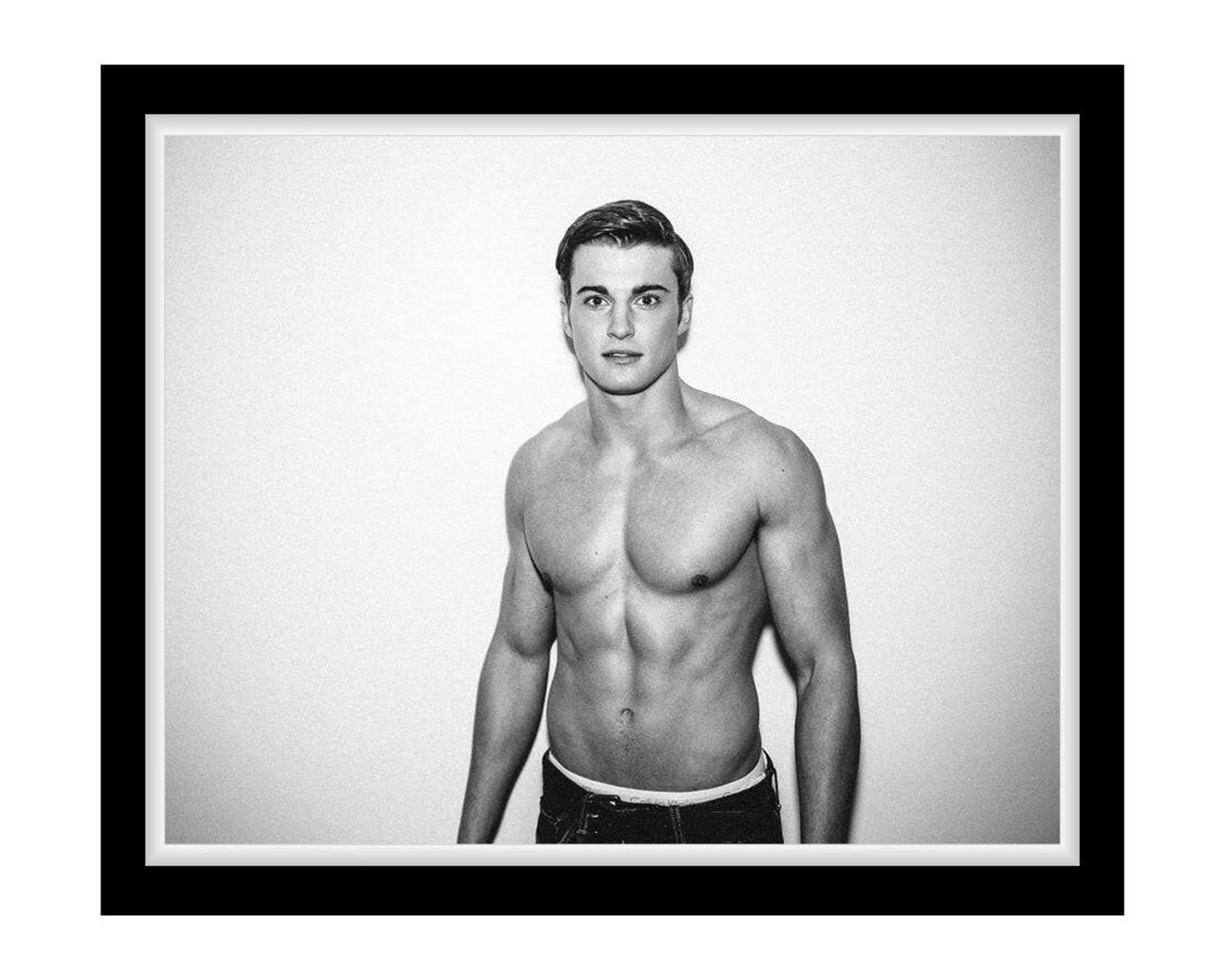 Black and white portrait of a shirtless man against a plain background