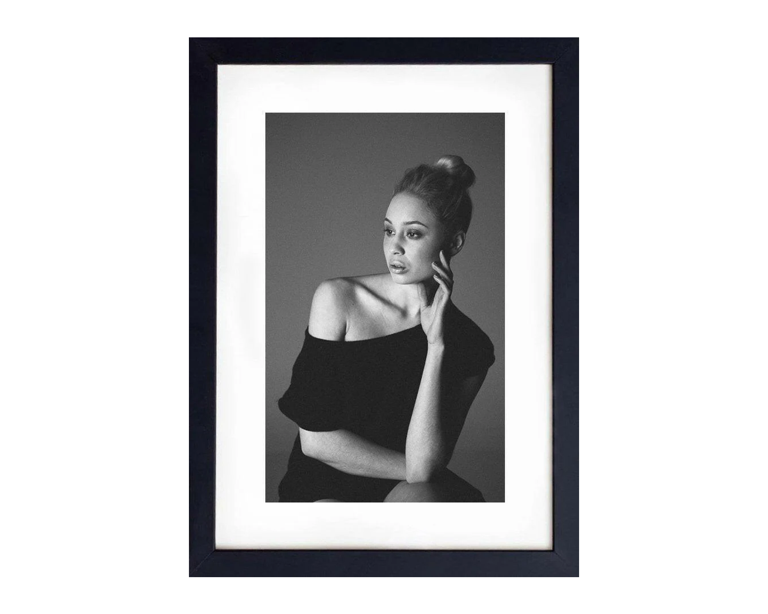 Framed black and white portrait of a woman with a bun.