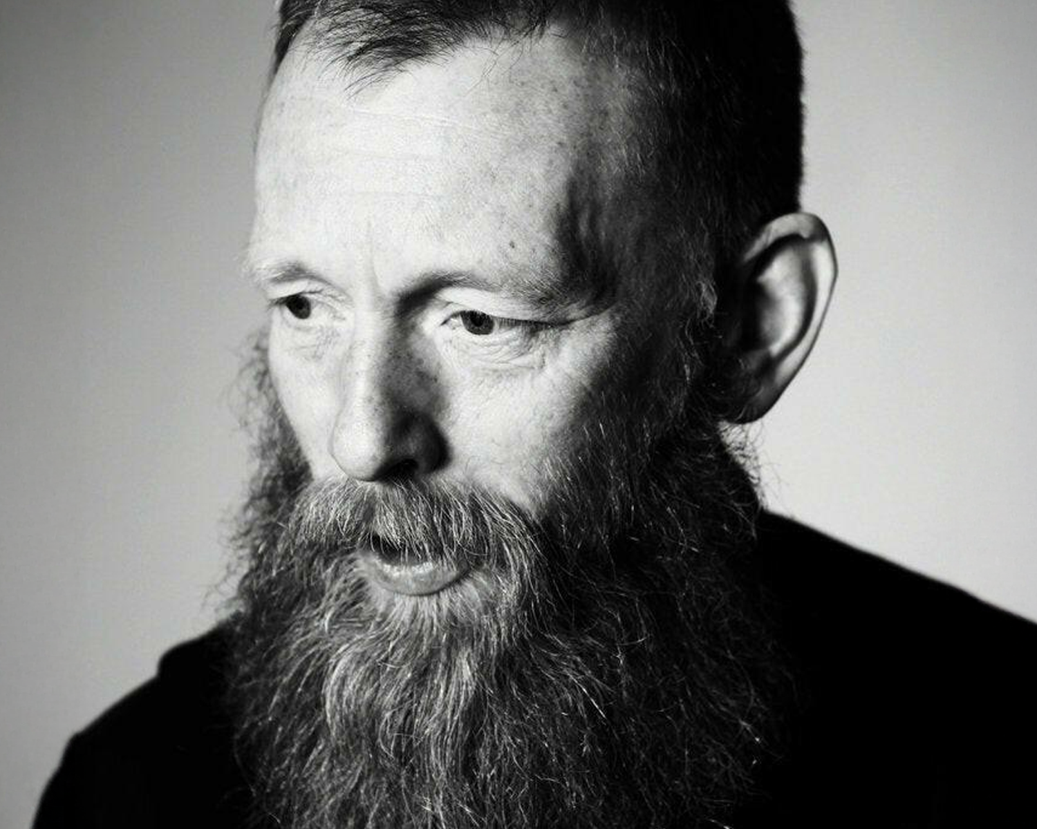 Black and white portrait of a man with a beard against a plain background