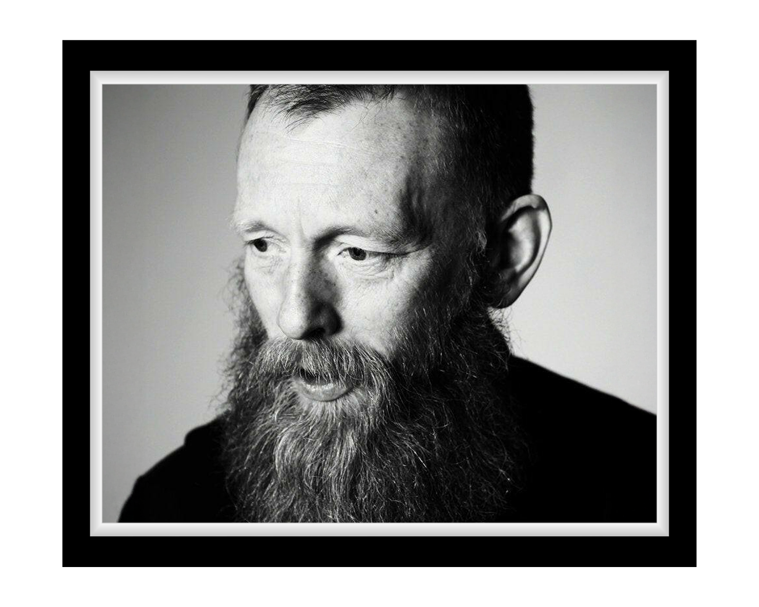 Black and white portrait of a man with a beard against a plain background