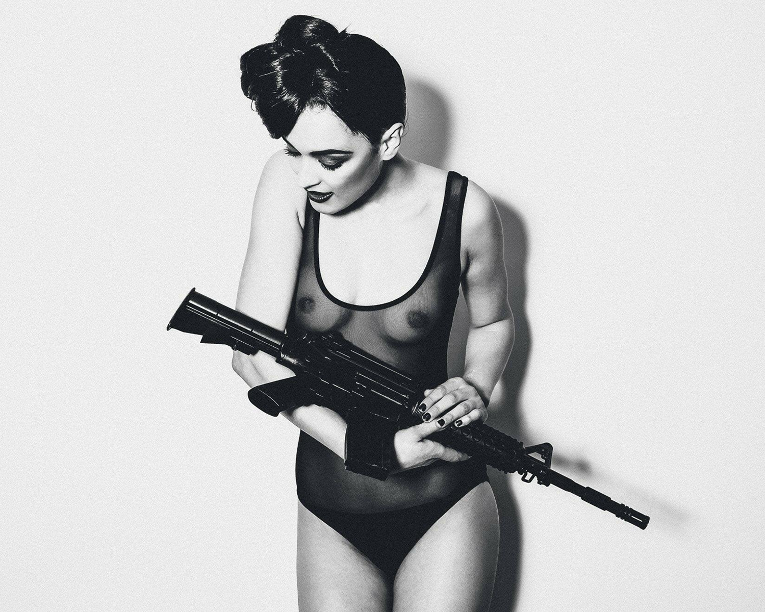 Lady in a swimsuit holding a rifle on a plain background