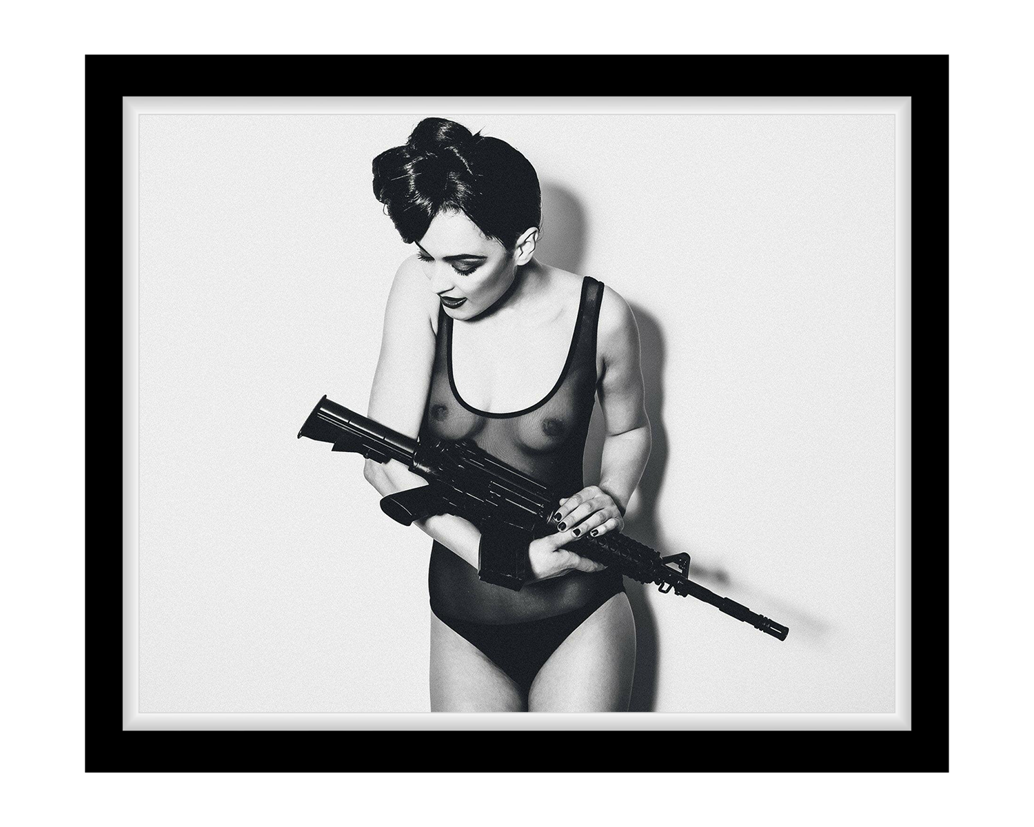 Black and white framed artwork of a Lady in a swimsuit holding a rifle.