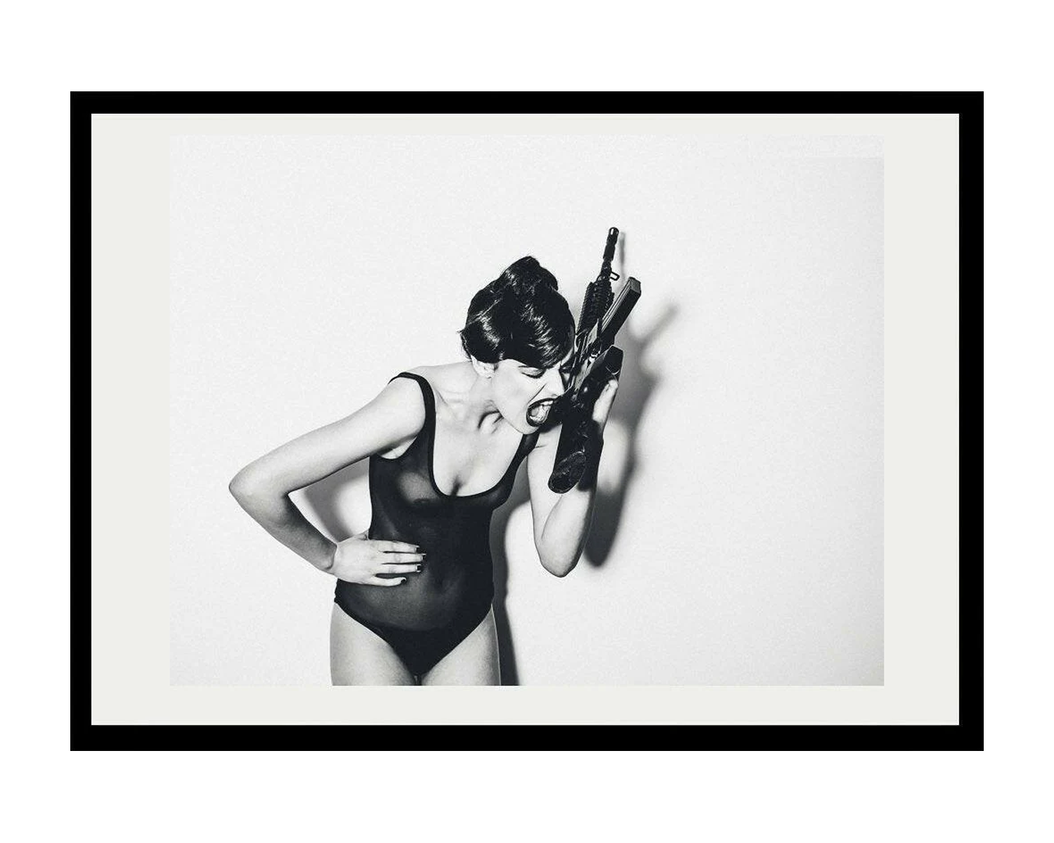 Framed black and white art print of a woman in a swimsuit with a gun.