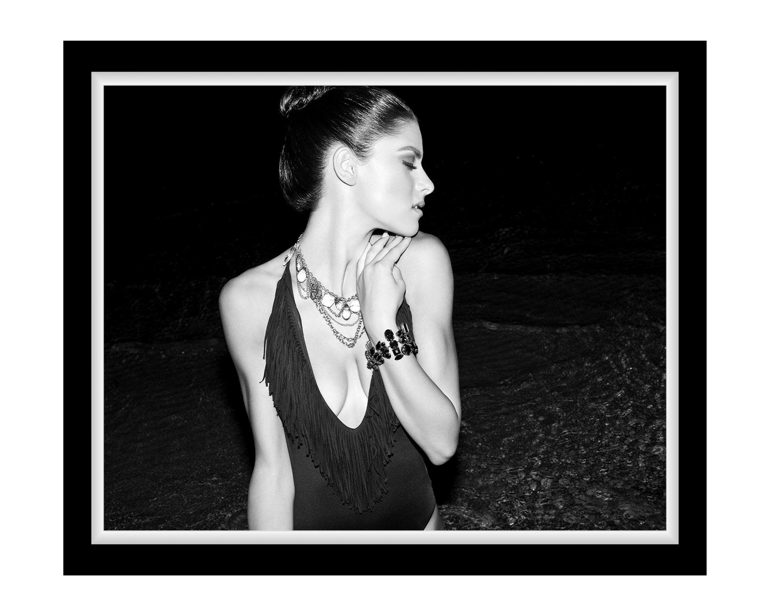 Black and white photo of a woman wearing a detailed necklace and bracelet.