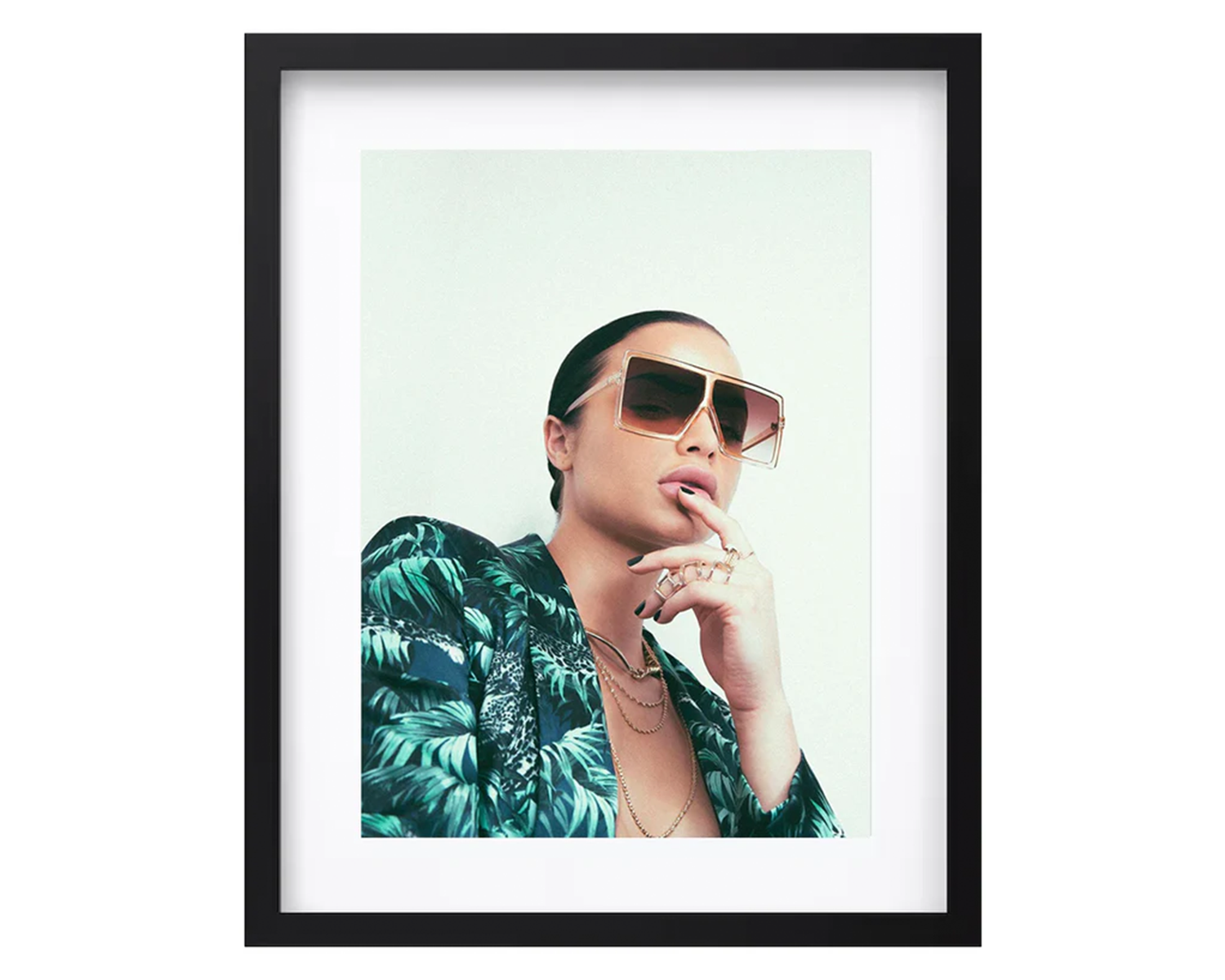 Framed portrait of a lady wearing sunglasses and a tropical shirt on a light green background