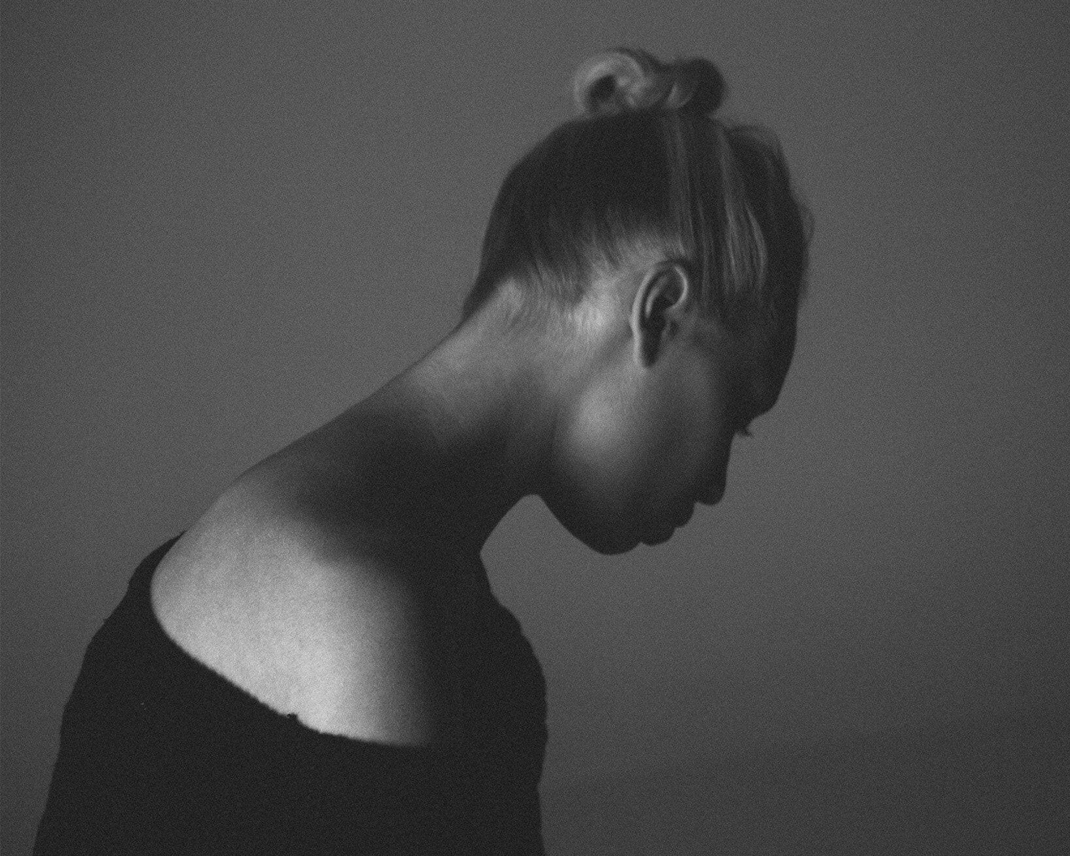 lady with hair in a bun against a plain background