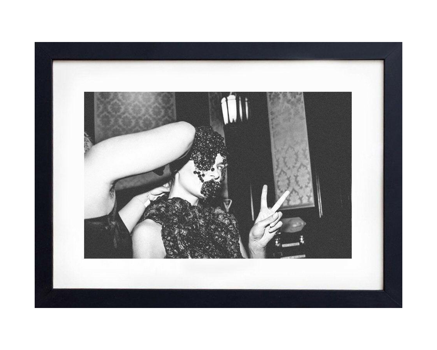 Framed black and white photograph of a woman making a peace sign.