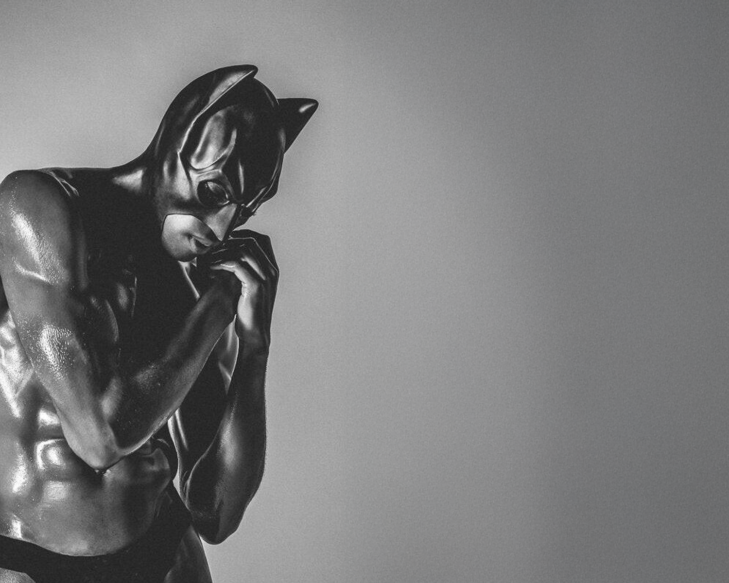 Statue of a muscular figure in a black mask against a gray background