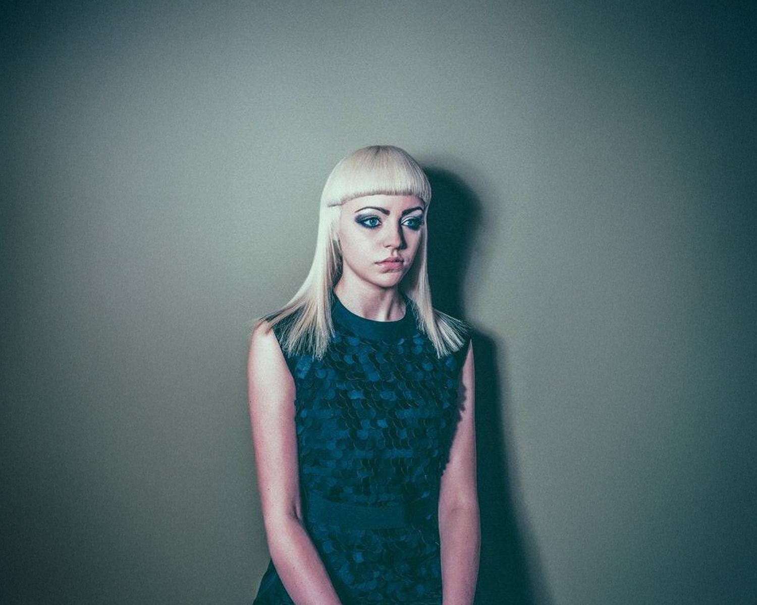 Girl with a blue patterned dress against a plain background