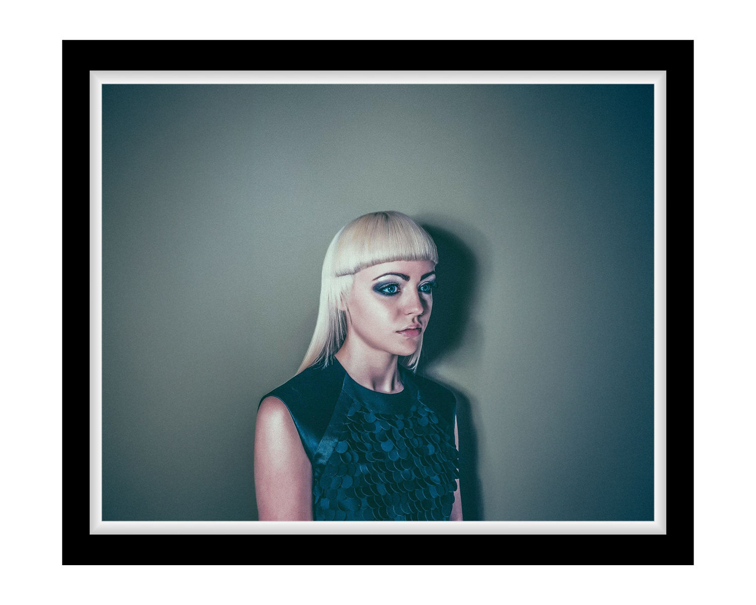 Lady with a short blonde hairstyle against a plain background