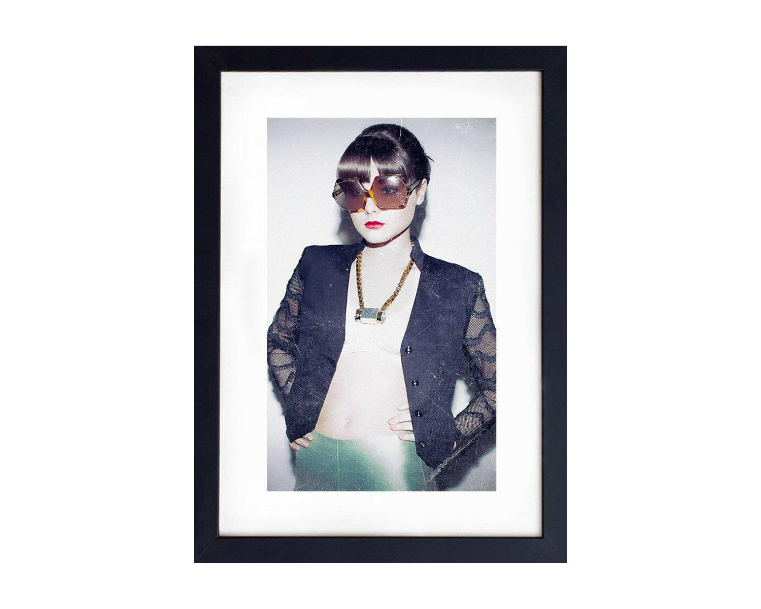 Framed portrait of a girl wearing sunglasses and a dark jacket.