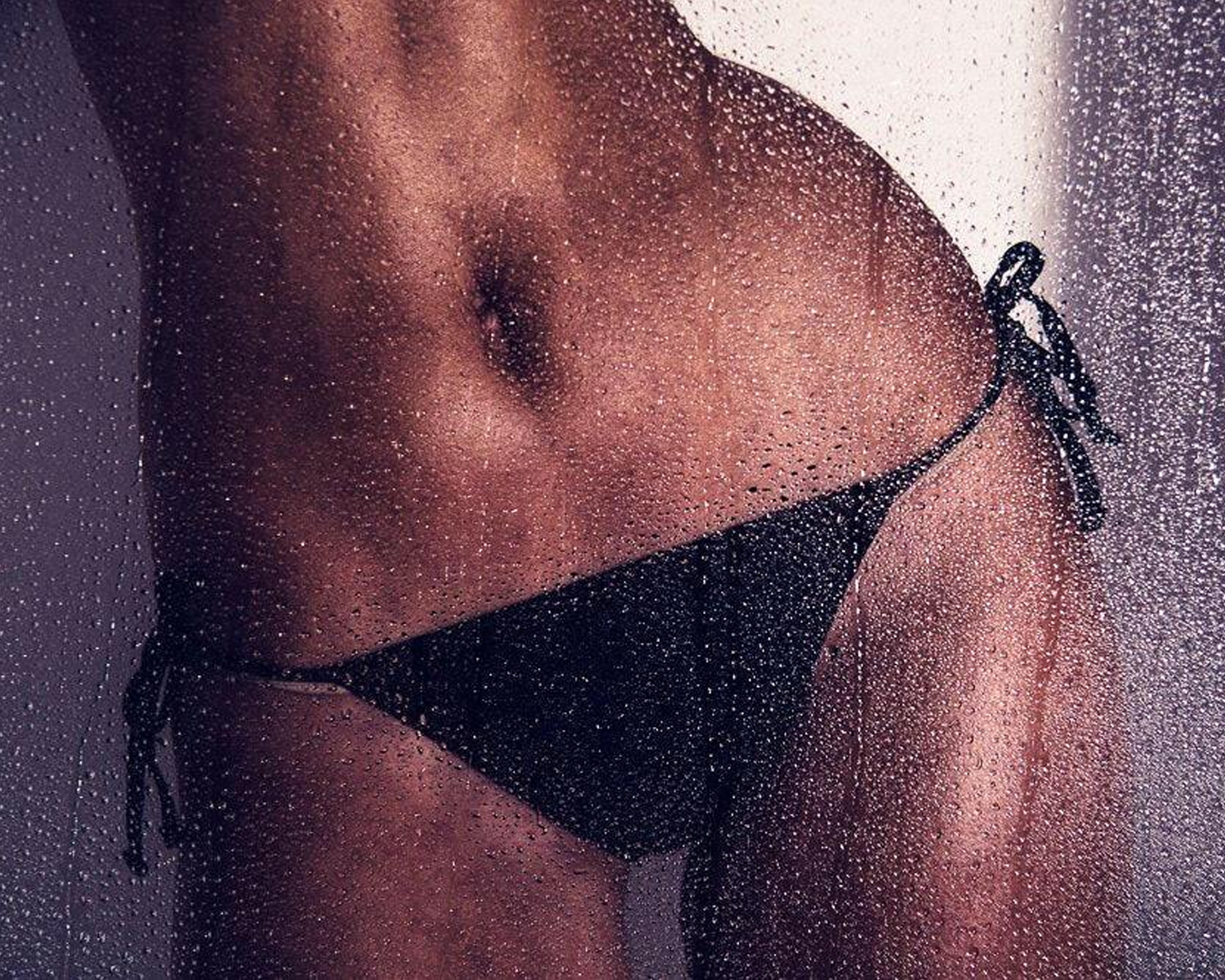 Lady wearing a black bikini with a blurred background