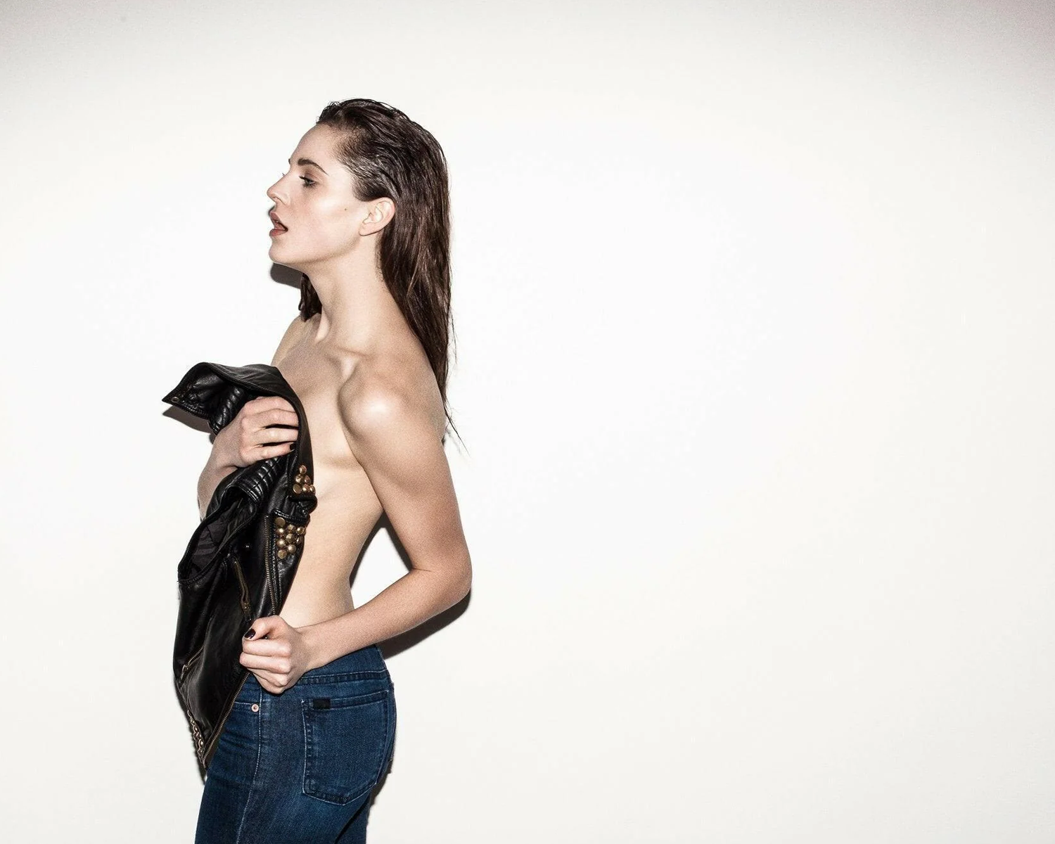 Woman holding a black jacket against a white background