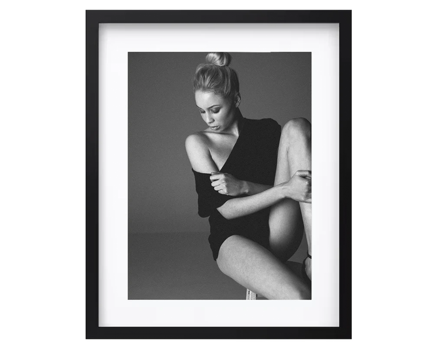 Framed black and white photograph of a woman sitting on a chair.