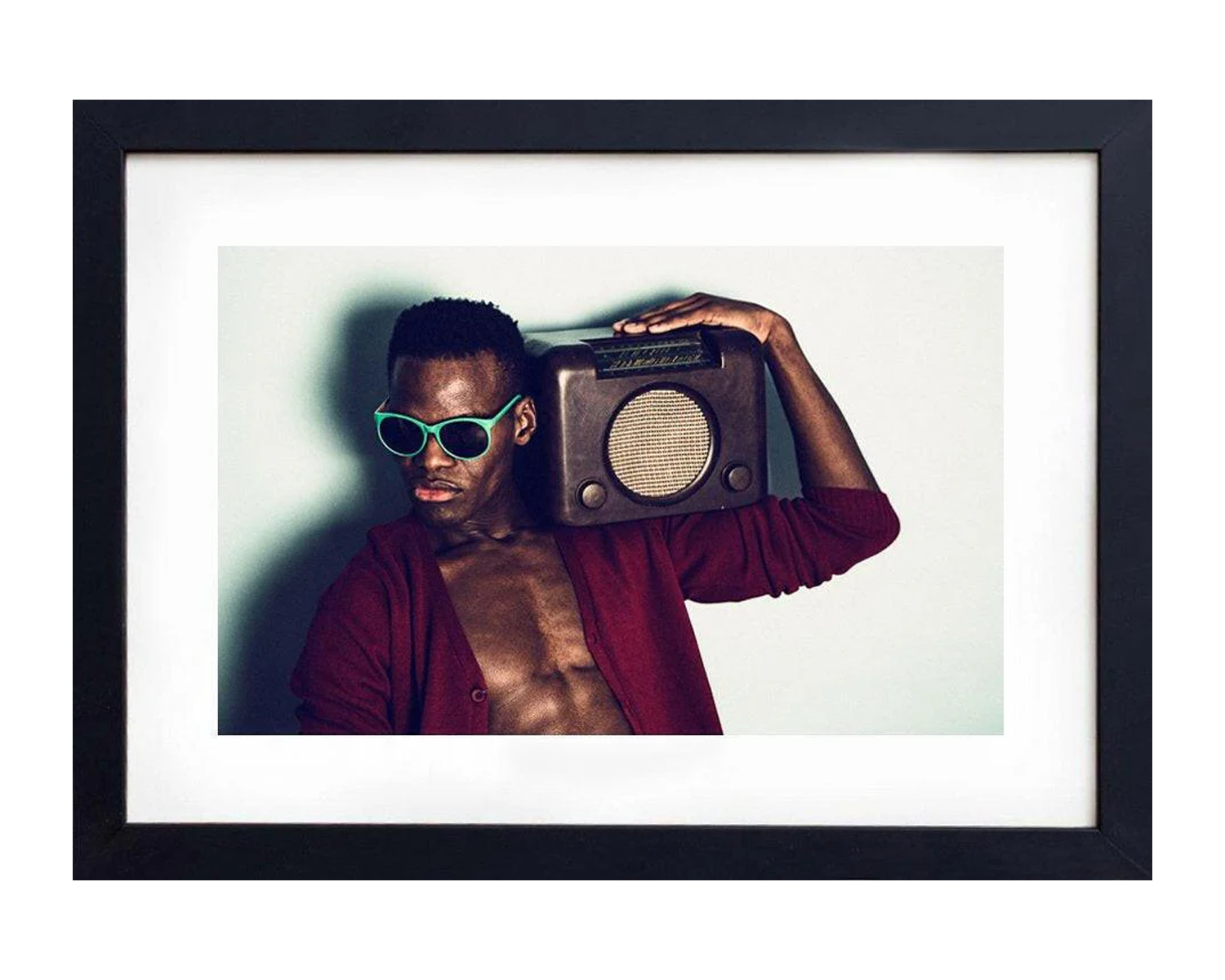 Man holding a vintage radio against his head with a black frame