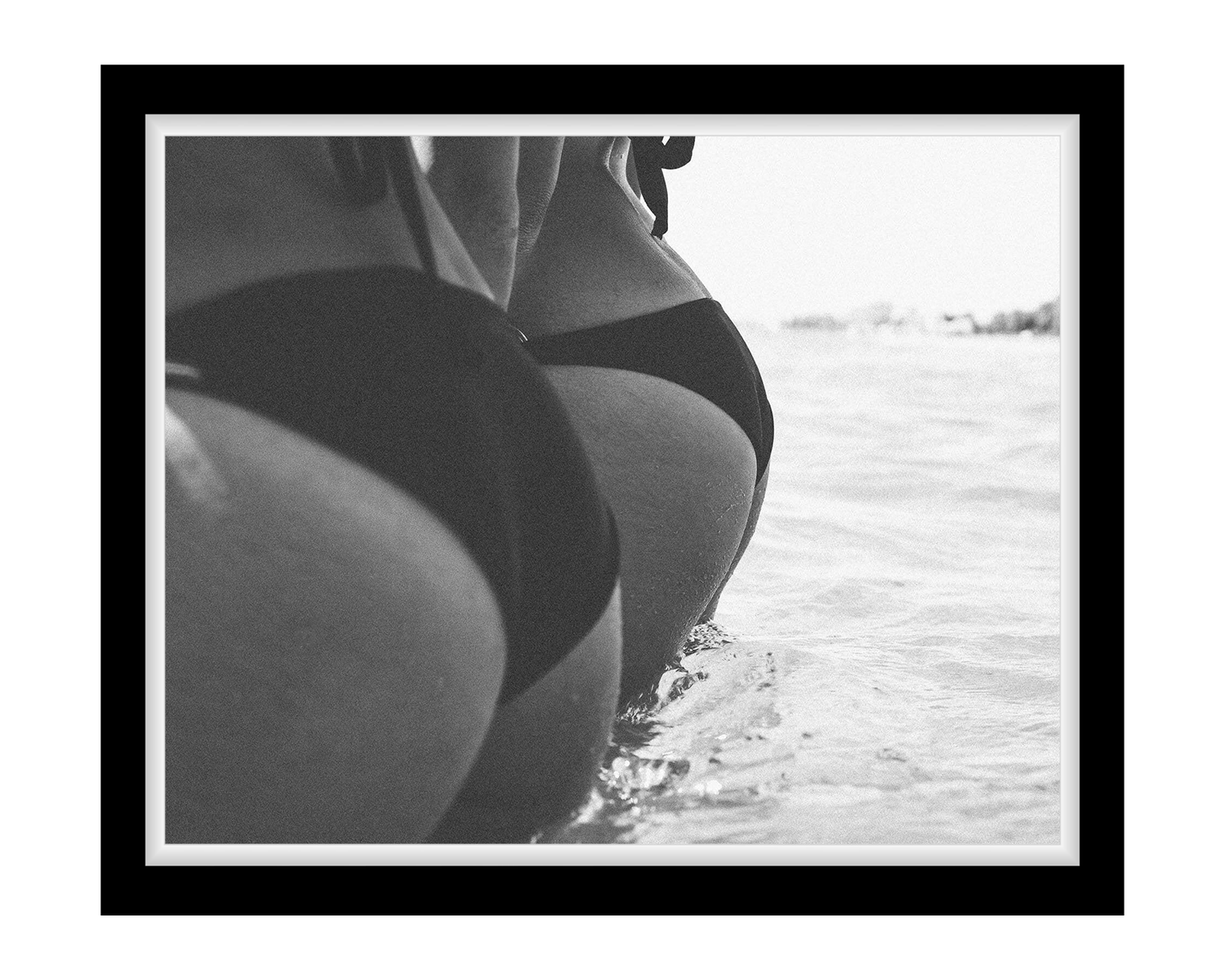 Black and white photo of 2 girl in a swimsuit by water