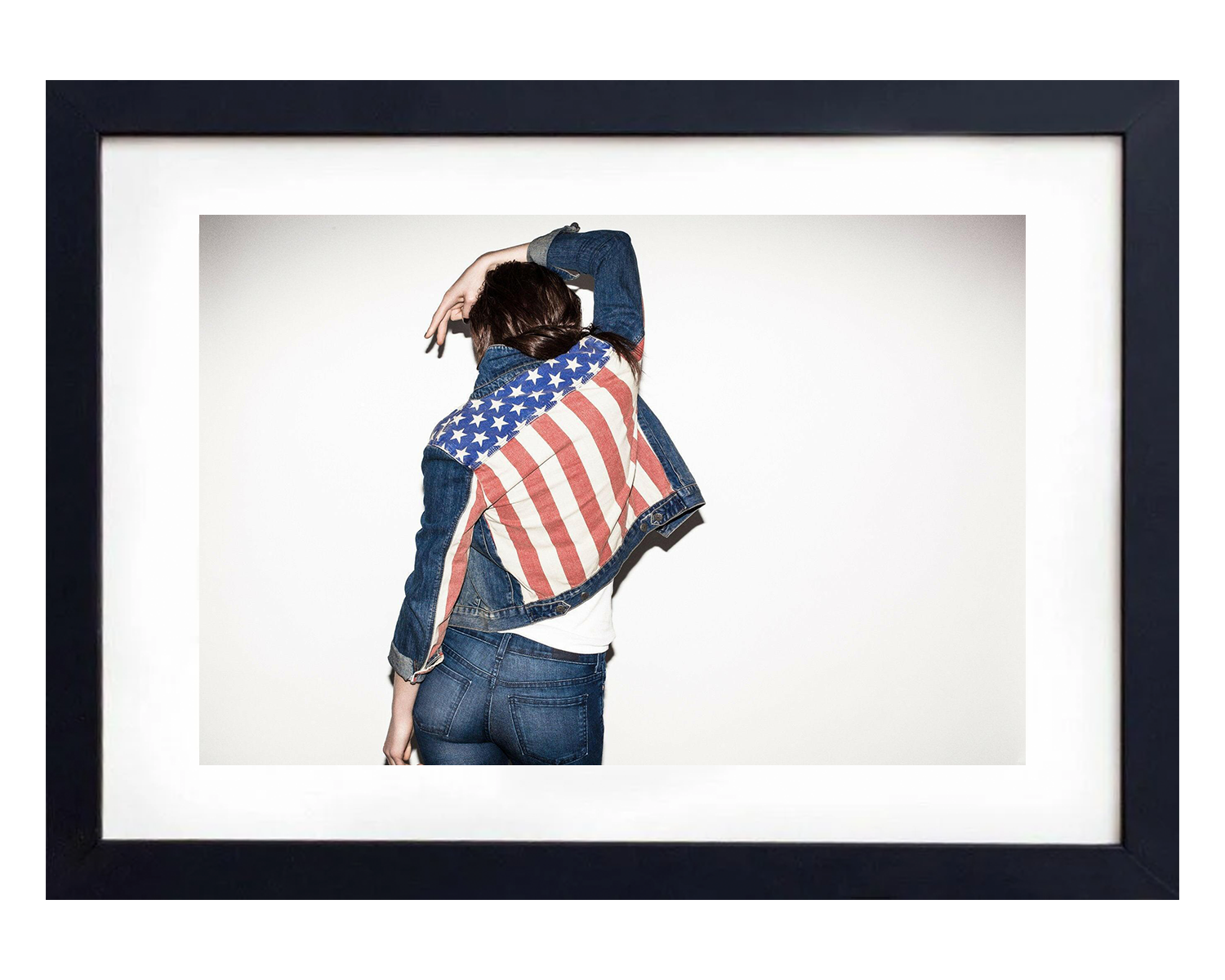 Person wearing a denim jacket with an American flag pattern, framed in black.