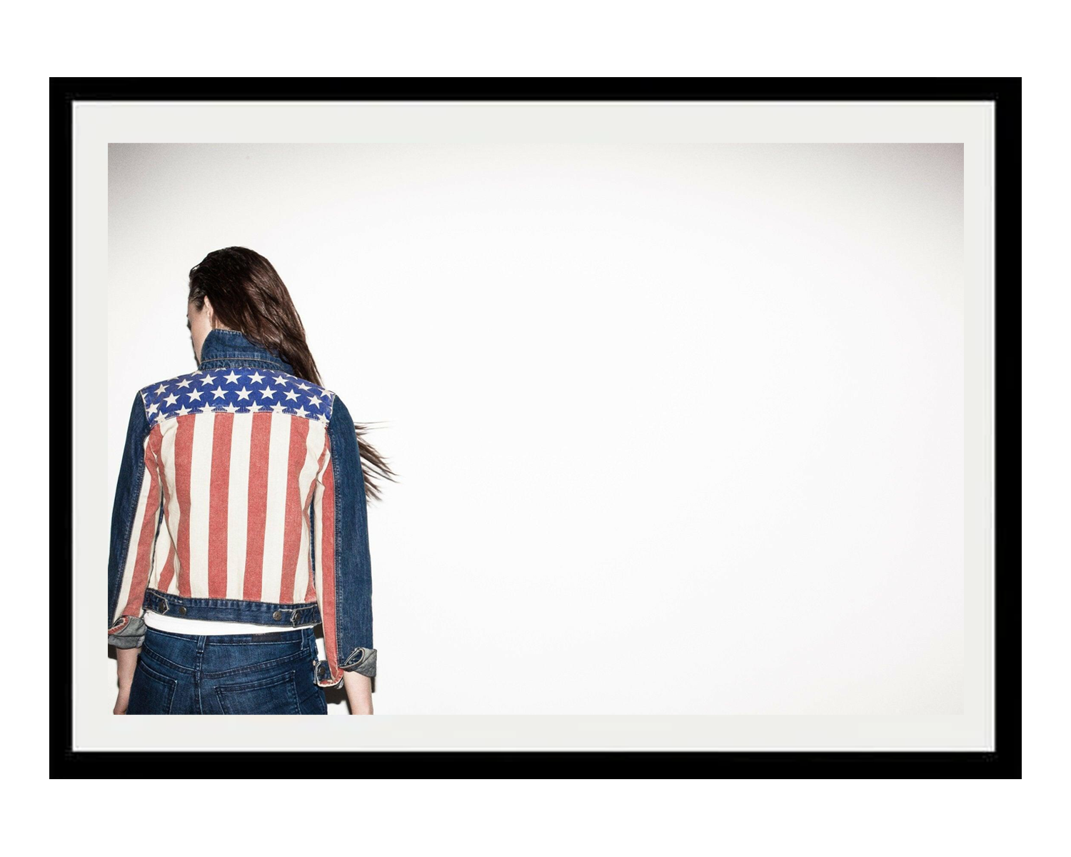 Person wearing a denim jacket with an American flag pattern on a white background
