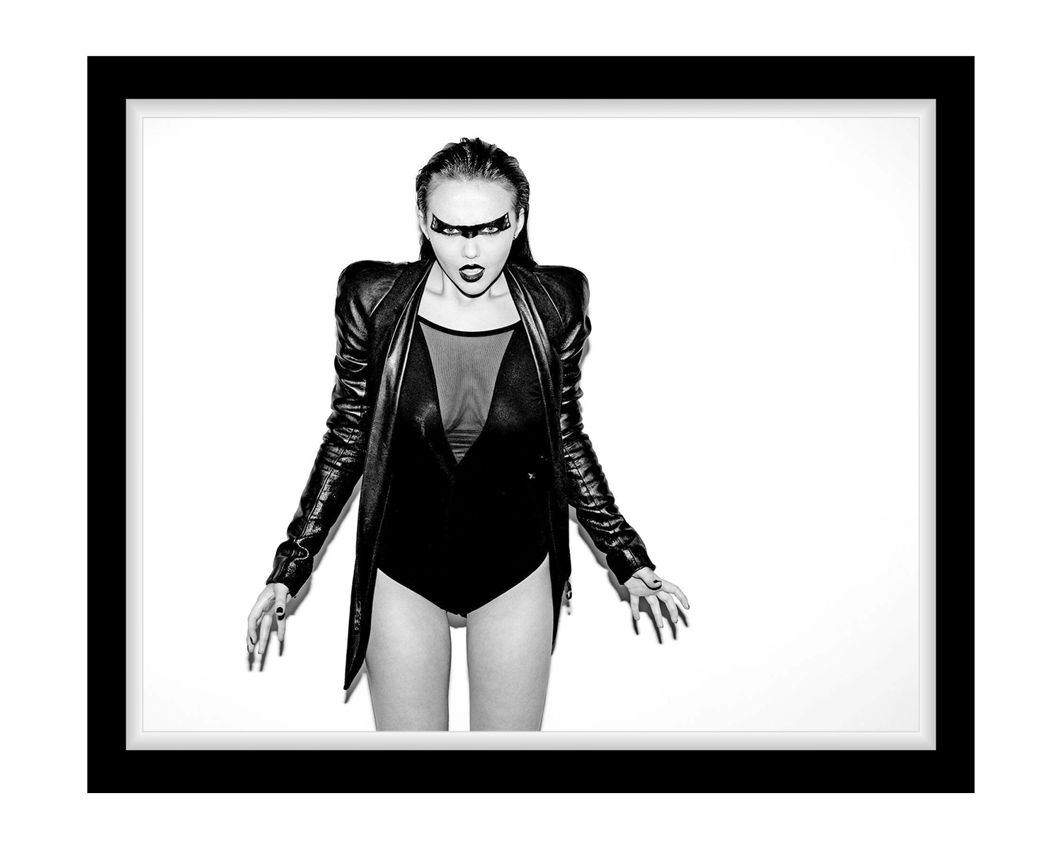 A woman in a black leather jacket paired with black underwear, showcasing a bold and edgy fashion statement, framed in black.